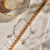Silver miniature lemon, citrus wedge, and pear jewellery charms on a silver paper clip chain.